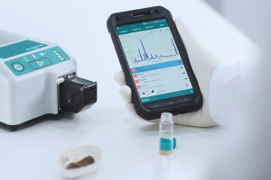 Photo of the Metrohm Instant SERS Analyzer and app on phone