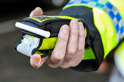 Photo of a policeman holding a breathalyser