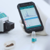 Photo of the Metrohm Instant SERS Analyzer and app on phone
